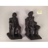 A pair of cast iron door stops in the form of a seated gentleman,