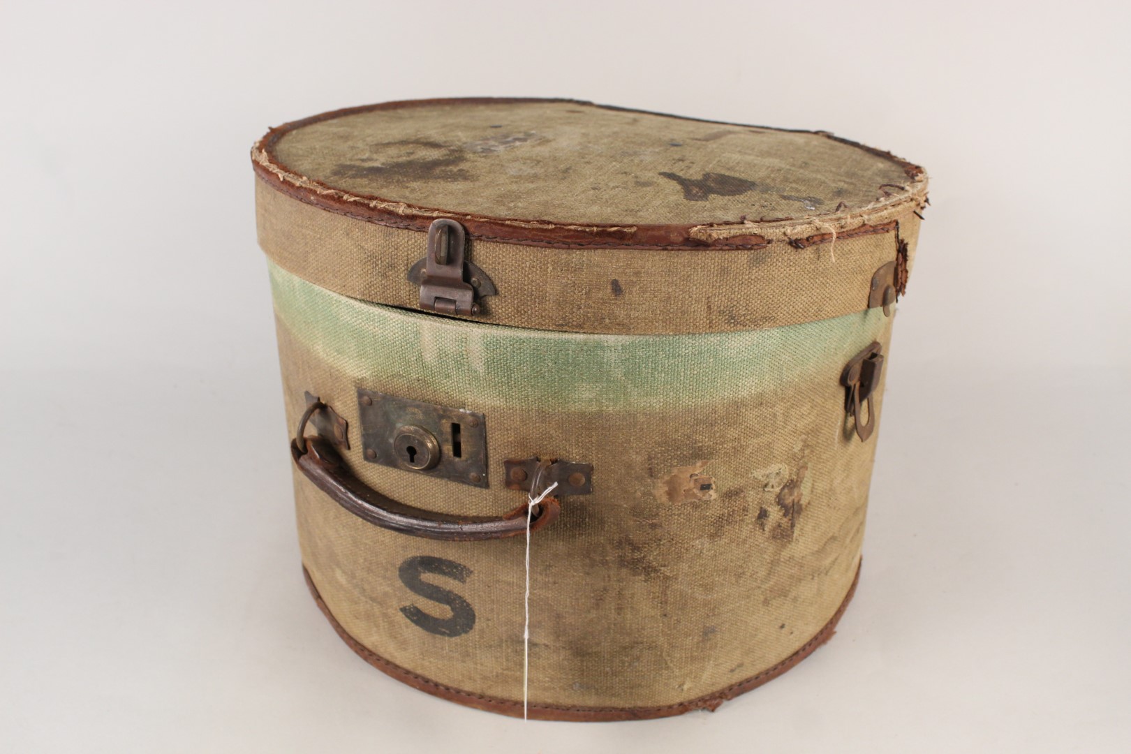 A vintage canvas covered hat box with brass lock and hasp