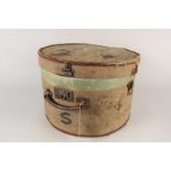 A vintage canvas covered hat box with brass lock and hasp