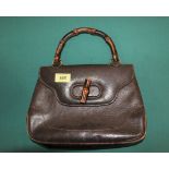 A vintage brown Gucci bamboo handbag with an assortment of various other handbags,