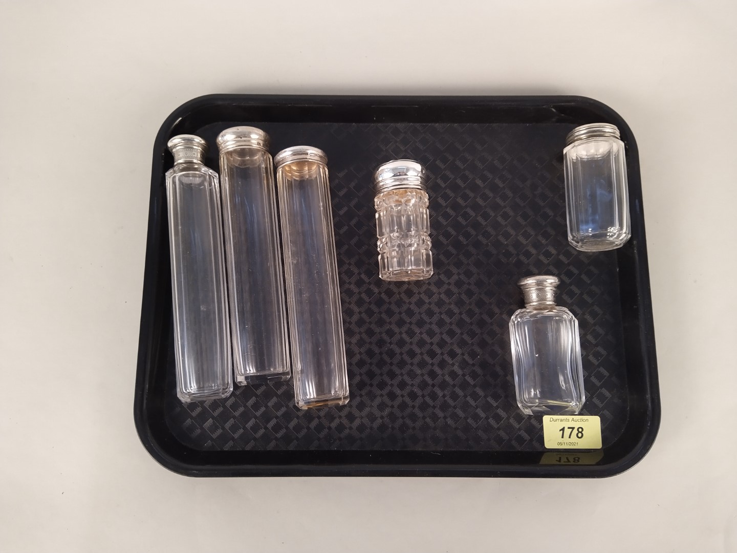 Six silver topped cut glass bottles from a fitted toilet box