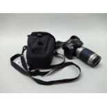 A Nikon D80 camera body with a Nikon 70-300mm lens and charger with a Lowe Pro case