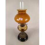 A Victorian brass oil lamp with pale amber glass reservoir