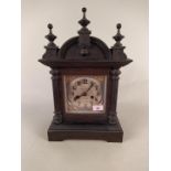 An Edwardian mantel clock in a stained pine case