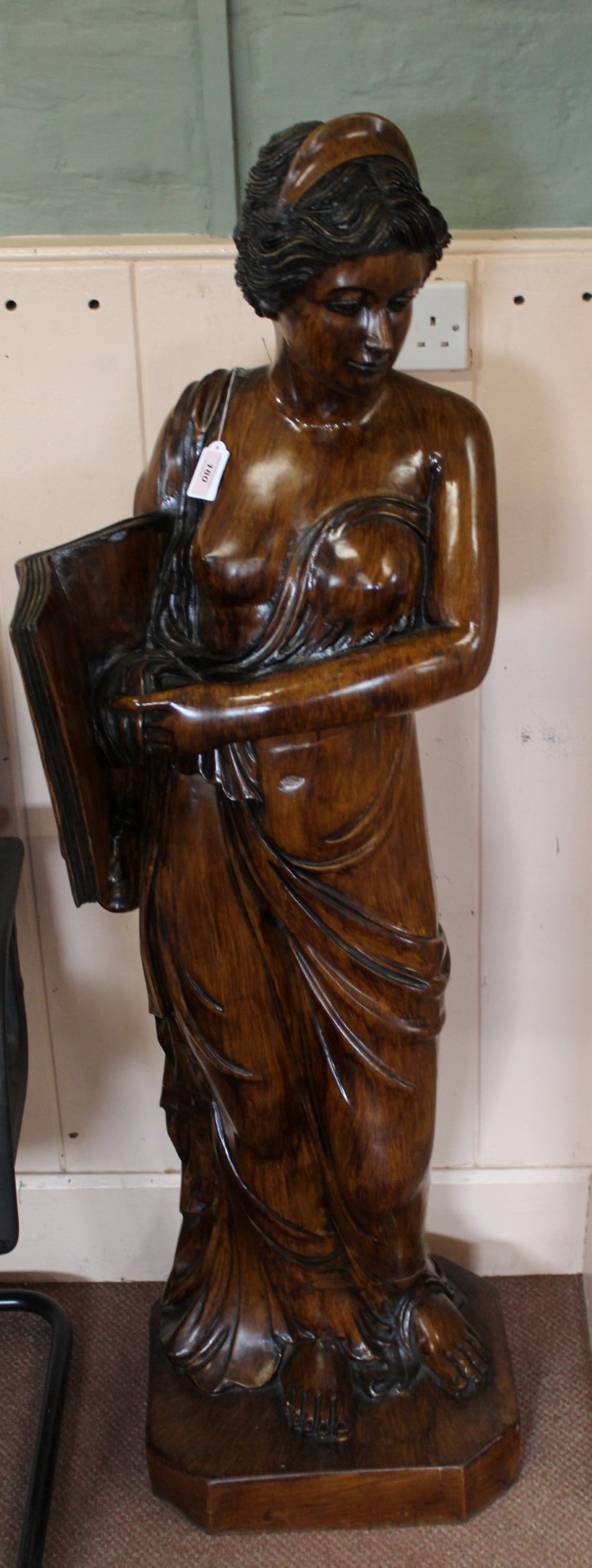 An unusual and imposing large statue of a classical lady holding a book constructed from a hand