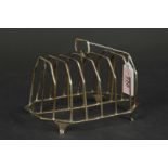 A large silver toast rack (split and repaired), hallmarks are too rubbed to accurately identify,