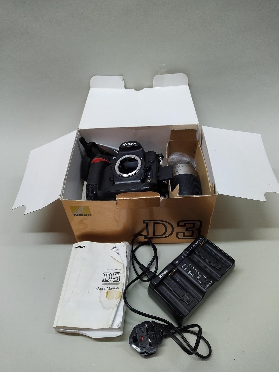 A Nikon D3 camera body with a Nikon 70-300mm lens and charger (as found) in original box