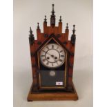 A late Victorian walnut cased steeple mantel clock