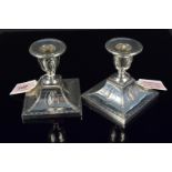 A pair of Adams style silver candlesticks with embossed images of Greek women and floral swag