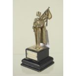 A silver figure of a pipe playing Gurkha on wooden plinth,