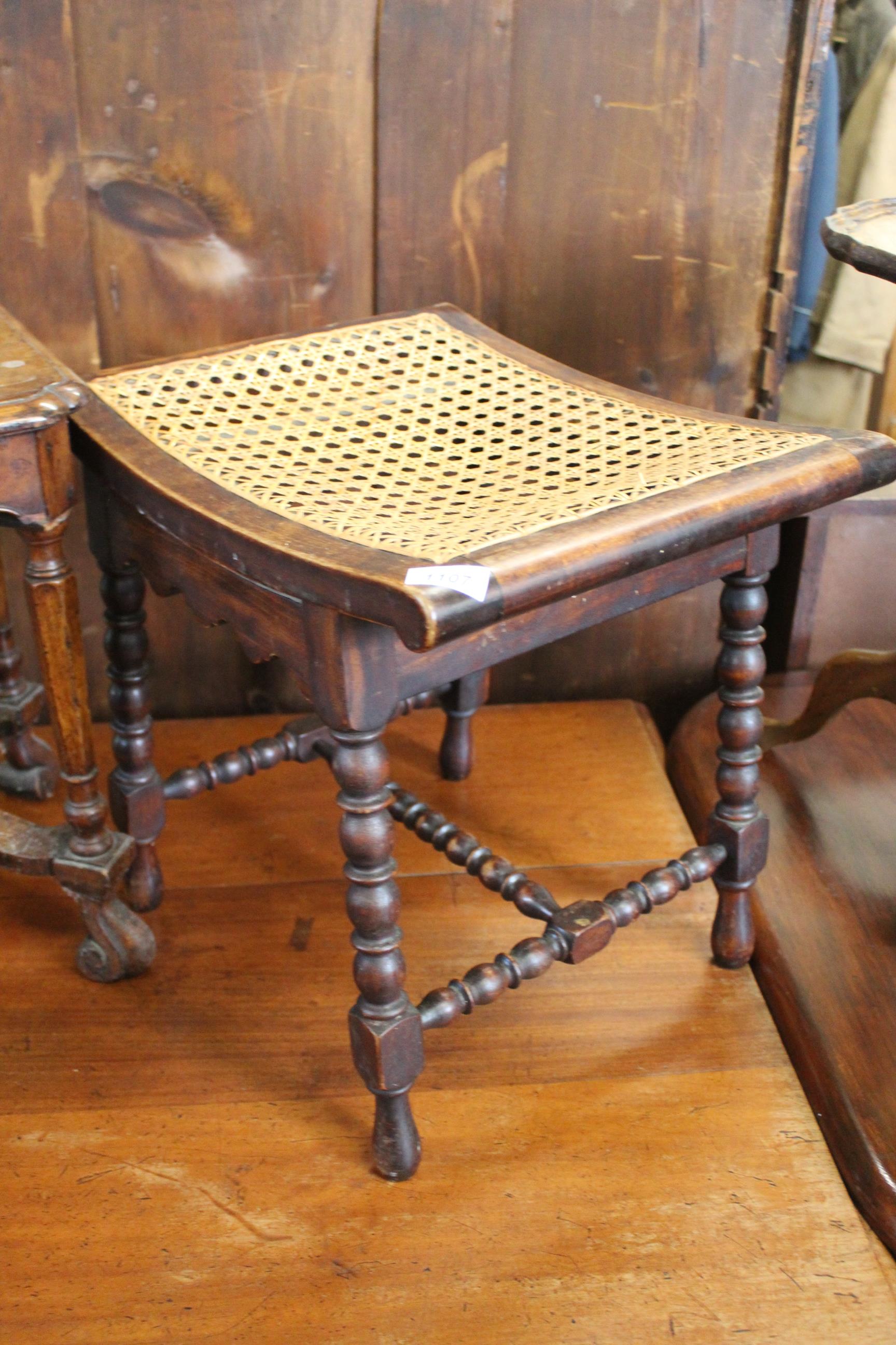 A late 19th Century mahogany bobbin turned stool with bergere seat
