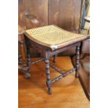 A late 19th Century mahogany bobbin turned stool with bergere seat