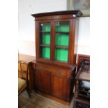 An Edwardian American walnut two door glazed cupboard bookcase