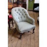 An early Victorian carved mahogany upholstered button back armchair