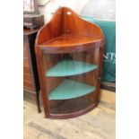 A George III mahogany bow fronted glazed corner cabinet with reeded mouldings