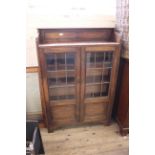 A 1940's oak two door adjustable bookcase with lead lined doors