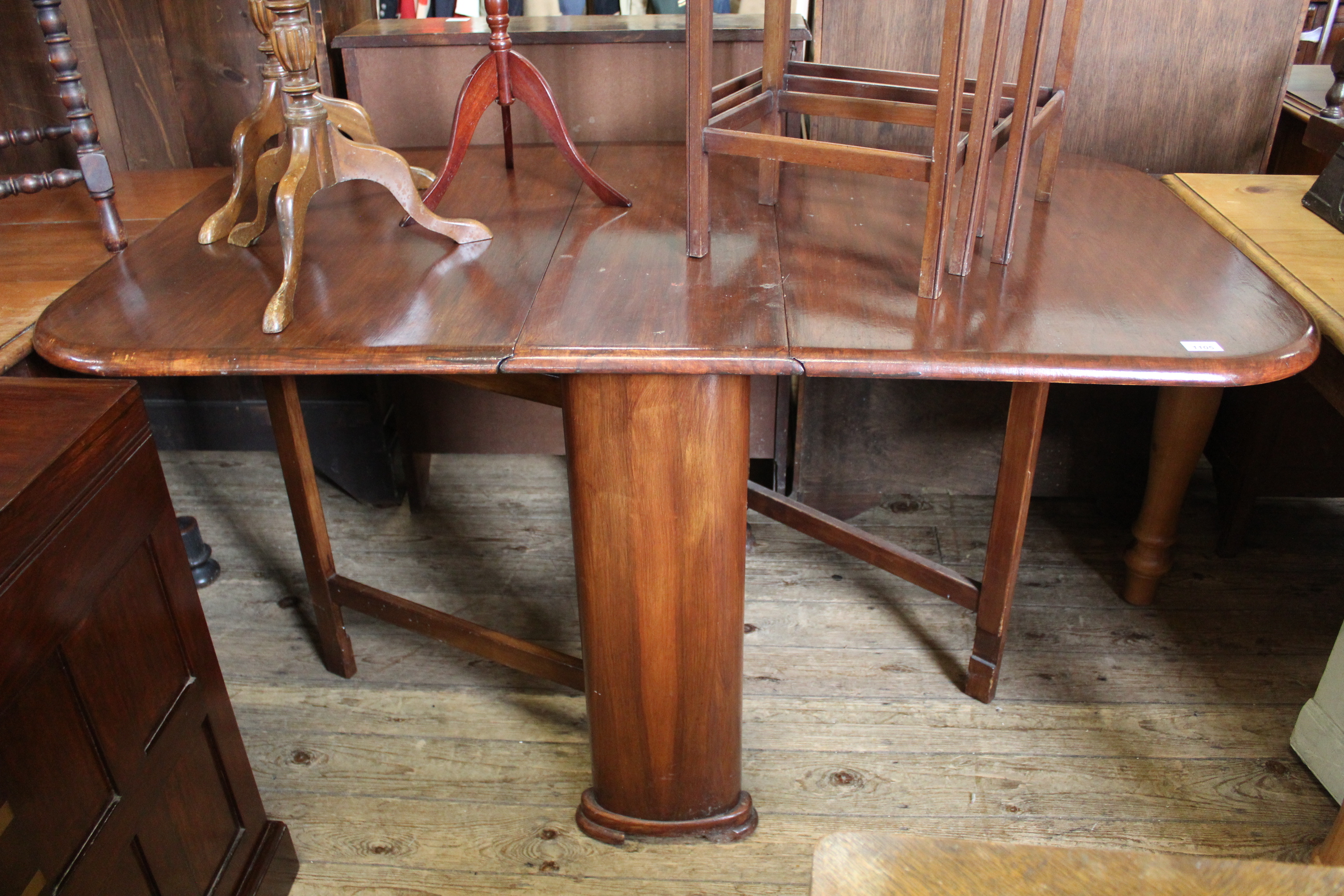A 1930's stained mahogany drop leaf dining table with unusual curved ends