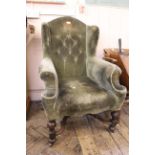 An Edwardian walnut x-framed wing back armchair in the William and Mary style