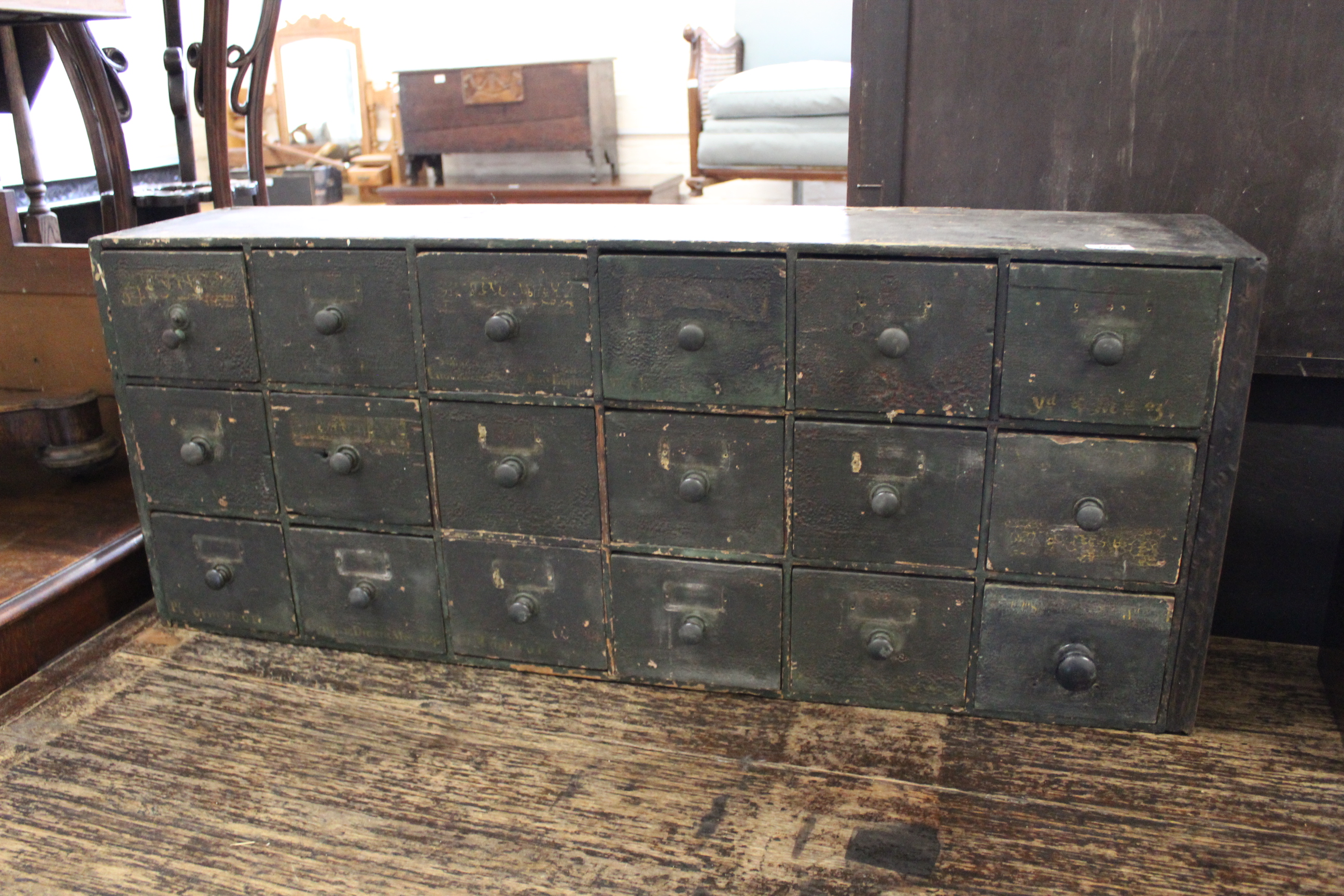 A late 19th Century bank of eighteen drawers, original finish with original writing in places,