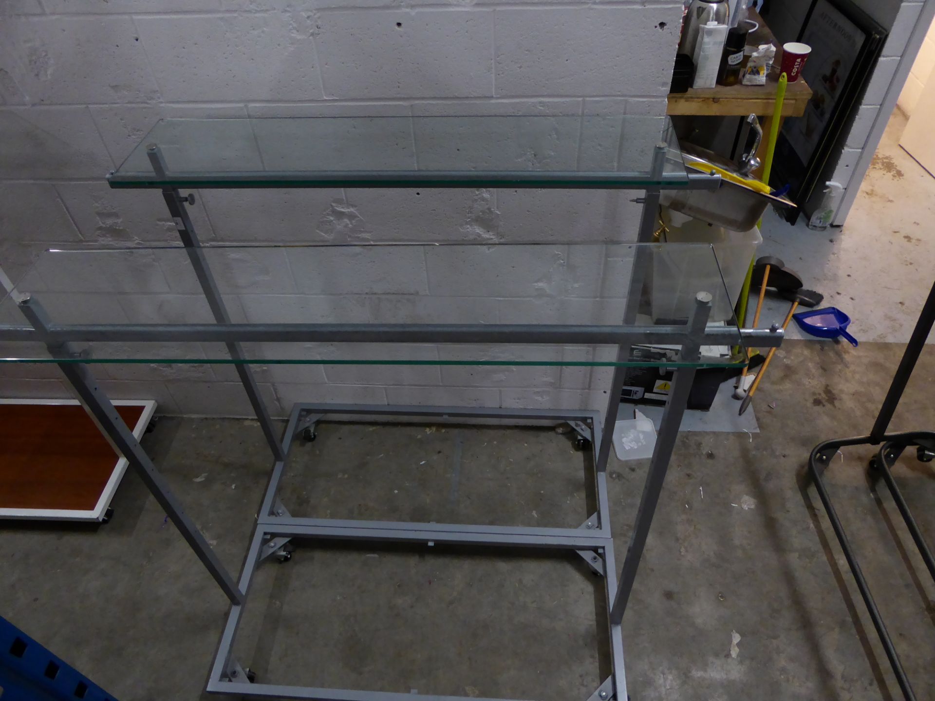 * 2 x metal rails with glass over shelf on castors. Adjustable height. 1600w x 500d x 1400h (min)