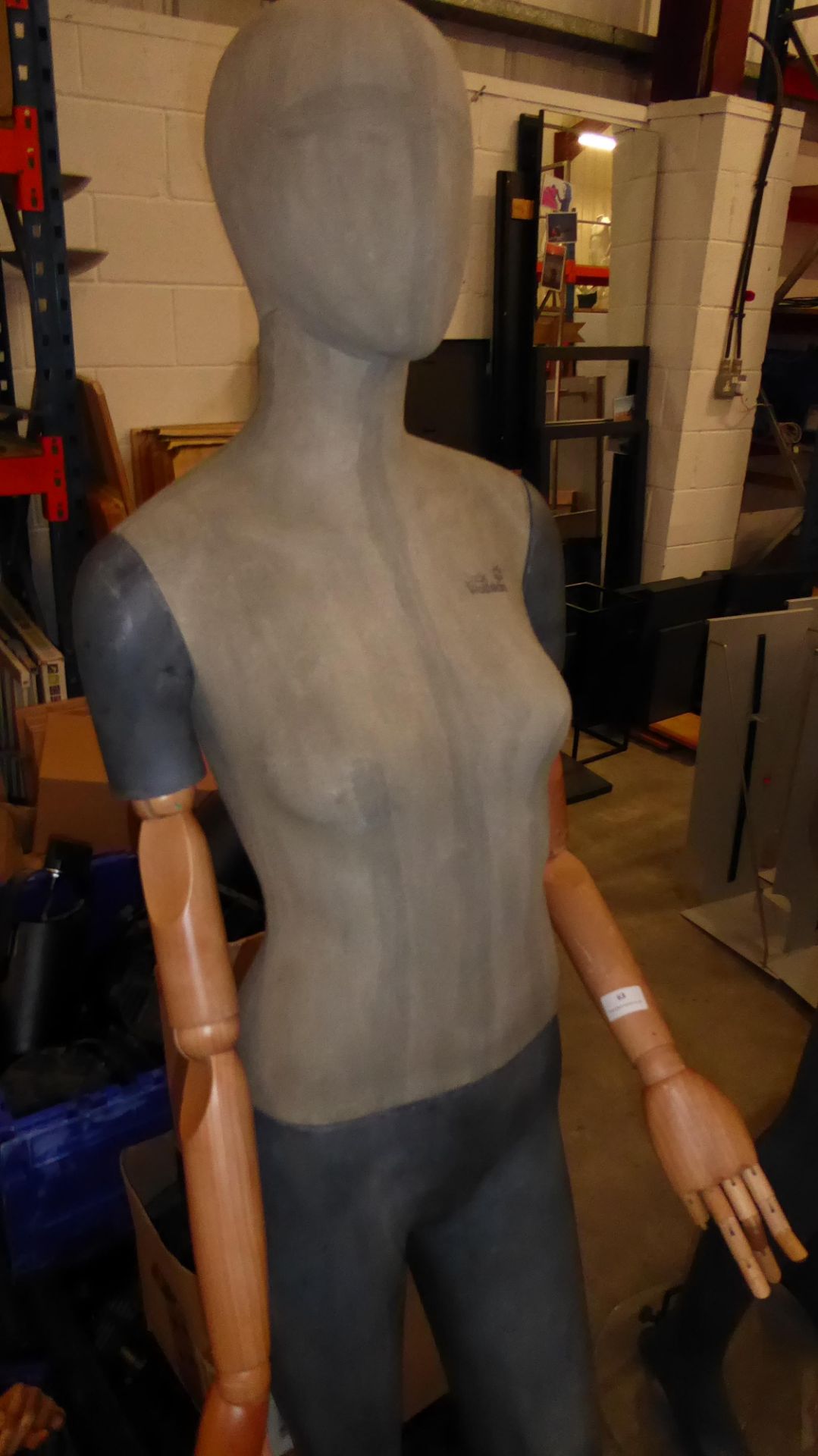 * Tall female mannequin with wooden articulated arms and glass stand.