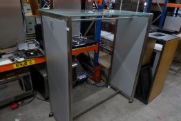 * mobile clothing display gondola with stainless steel finish and glass top. 1300w x 650d x 1550h