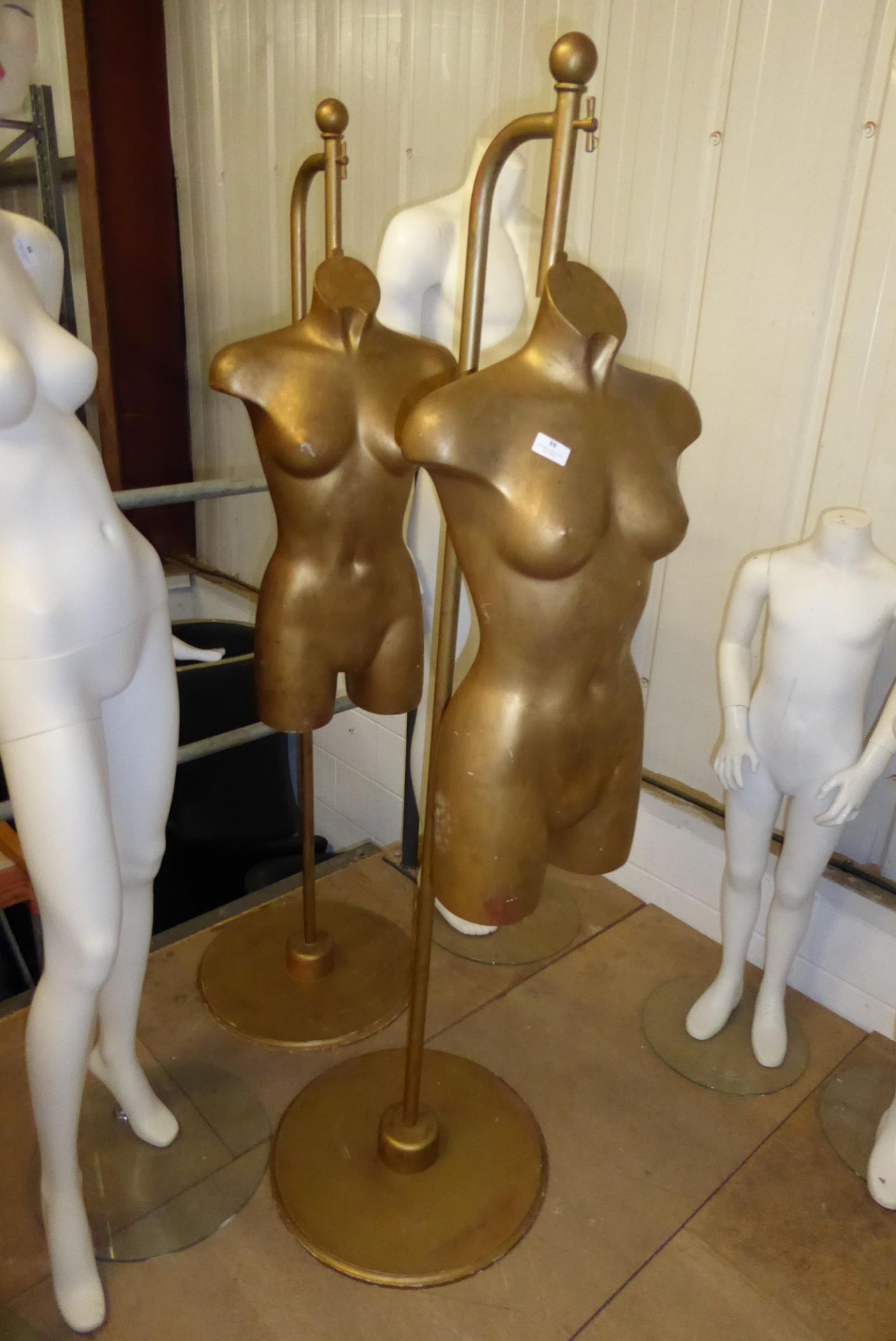 * Pair of suspended female torsos on stands with distressed gold effect