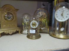 Four Glass Dome Clocks and Another