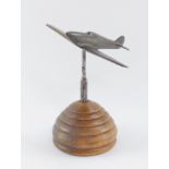 A brass desk stand modelled as a spitfire, raised on a bee hive shaped circular stand, 18cm high.