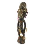 A Papua New Guinea Sepik carved wooden figure, modelled in standing pose, with a mask type head,