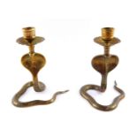 A pair of Indian early 20thC brass candlesticks, cast of cobras, 13.5cm high.