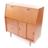 A Burolite teak bureau desk, the fall flap opening to reveal drawers and recesses, over two