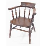 A Victorian oak and elm smoker's bow chair, with solid saddle seat, raised on turned legs united