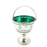 A George III silver sugar basket, with green glass liner, swing handle, pierced and engraved with