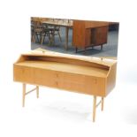 A Meredew mid-century vintage light oak dressing table, the tilting adjustable rectangular mirror