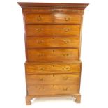 A George III mahogany chest on chest, the outswept pediment with dentil moulding over two short