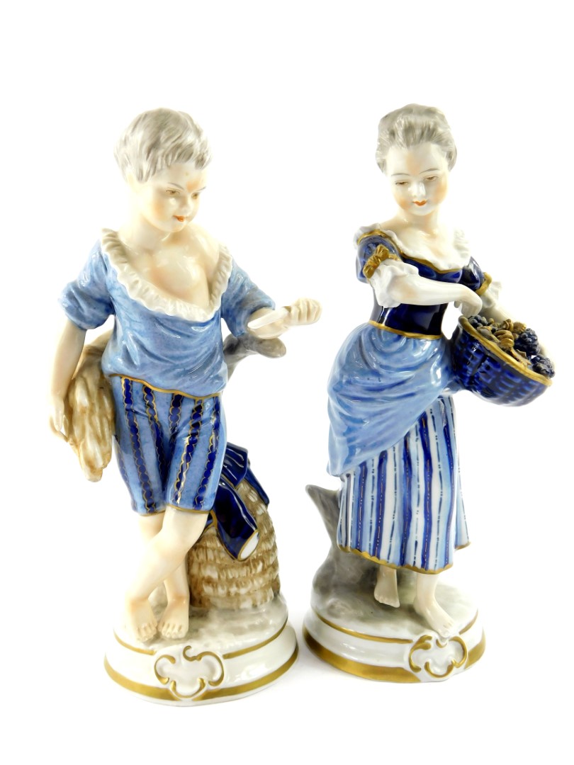 A pair of Unterweissbach 20thC porcelain figures, of a boy and girl, modelled standing with a sheath