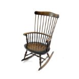 A dark oak and ash comb back Windsor rocking chair.