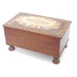 A Victorian oak ottoman, with a floral wool work seat, raised on bun feet, 38cm high, 73cm wide,