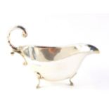 A silver sauce boat, with double C scroll handle, raised on three hoof feet, Birmingham 1970, 3.
