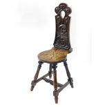A Victorian oak spinning chair, with a scrolling leaf carved back and seat, raised on baluster