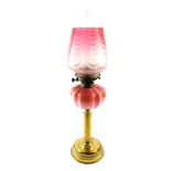 A Victorian brass oil lamp, with an enamel decorated Burmese glass reservoir, glass chimney and