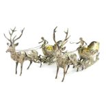A pair of Continental silver bonbon dishes, modelled as reindeer pulling sleighs, surmounted with