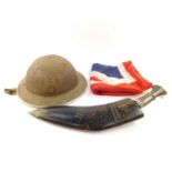 A World War I Brodie helmet, with leather lining and white metal trim, a kukri with damascene