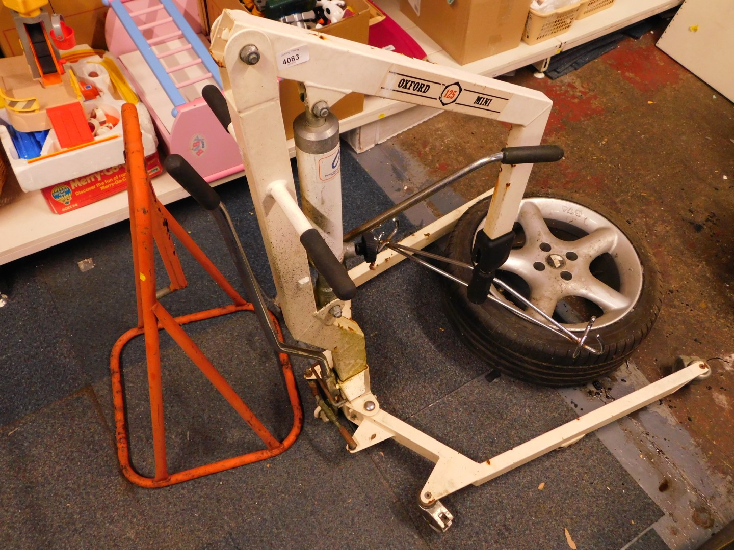 An Oxford Mini 125 hydraulic hoist, together with a Champion equipment stand, and an alloy wheel and