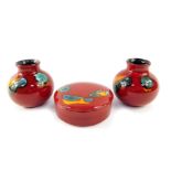 A group of Poole pottery decorated in the Volcano pattern, comprising a pair of vases, 10cm high,