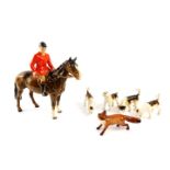 A Beswick pottery figure of a huntsman on a brown gloss horse, together with four hounds and a