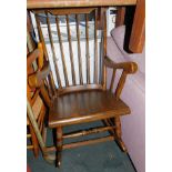 A late 20thC beech rocking chair, with spindle back and turned legs.