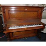 A Victorian walnut cased upright piano, makers label lacking, with carved pilasters, memorial plaque