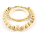 A bone necklace and bangle.